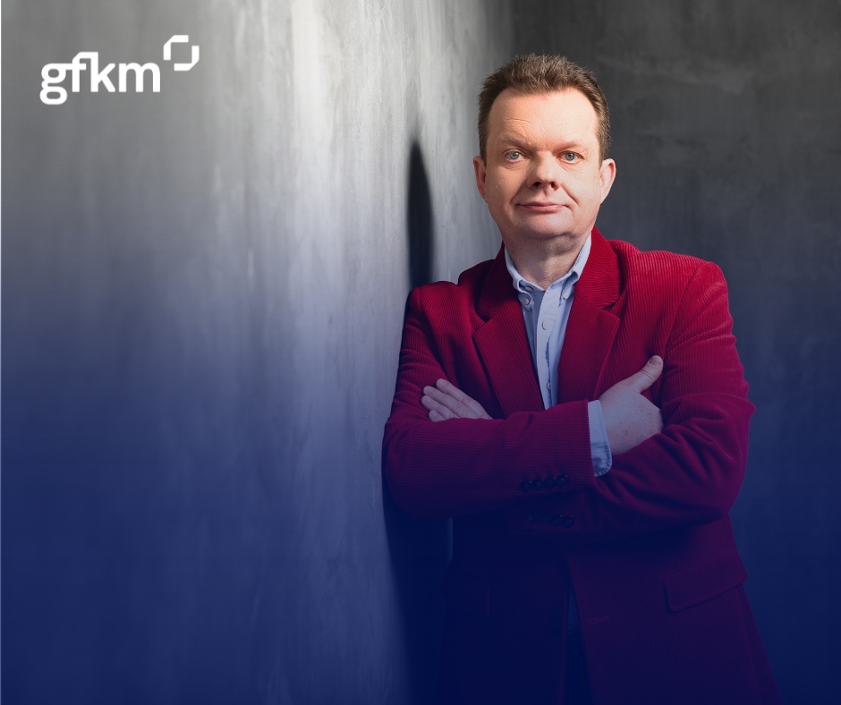 ekspert biznesu w czerwonej kamizelce opierający się o ścianę