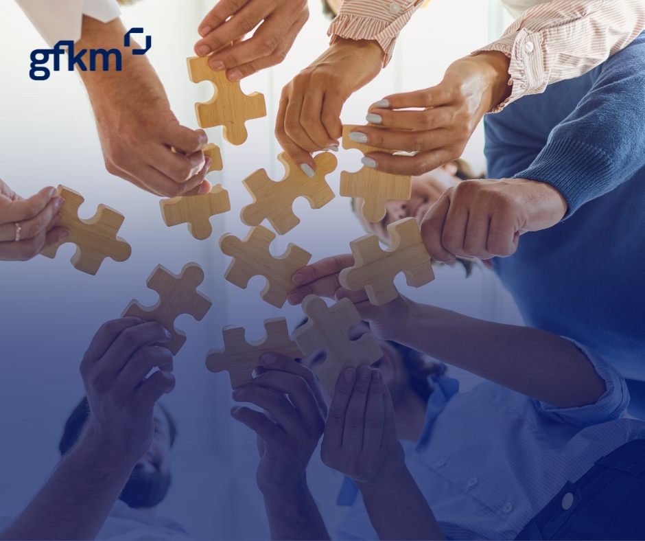 Grupa ludzi trzymająca w dłoniach fragmenty puzzli, które chcą złożyć w całość